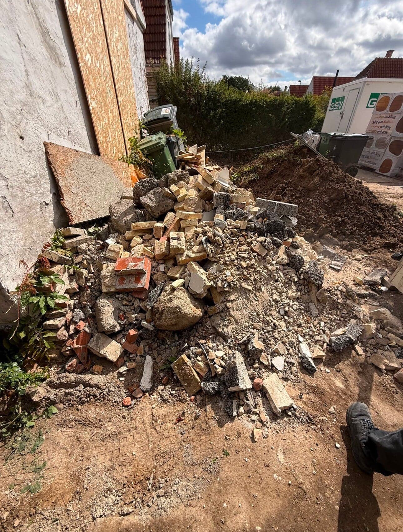 Bunke af mursten og murbrokker ved et hus